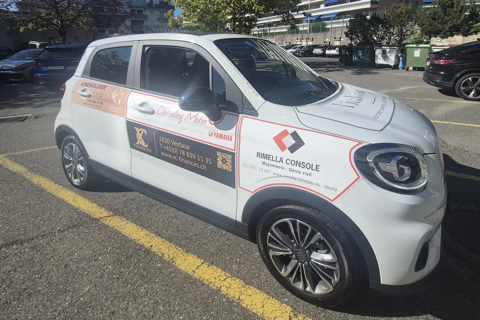 La voiture Vitaloria vue de trois quarts, habillée des logos des entreprises partenaires
